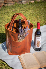 Elegant light brown bag that carries wines and wine glasses with some flowers in the front pocket