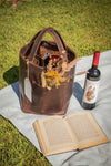 Elegant brown bag that carries wines with some flowers in the front pocket